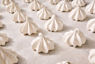 Meringue Kisses in neat rows on a counter.