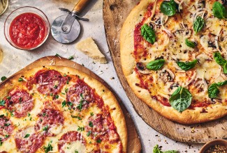 Two pizzas seen from above on wooden pizza peels