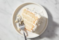 A single slice of Coconut Layer Cake on a plate with a fork
