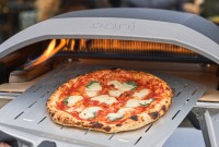 Pizza being pulled from Ooni pizza oven