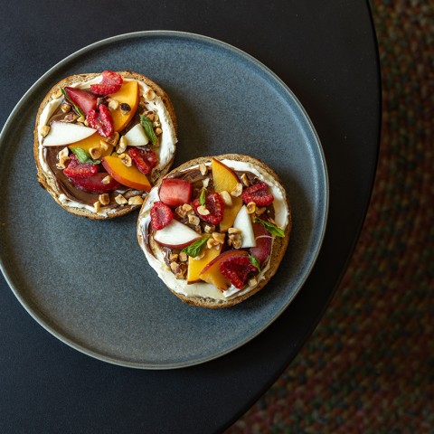 Two individual pizzas photographed from above on a dark gray plate. - select to zoom