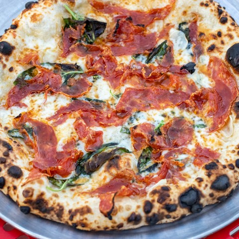 Photograph of a wood fired pizza on a blue plate. - select to zoom