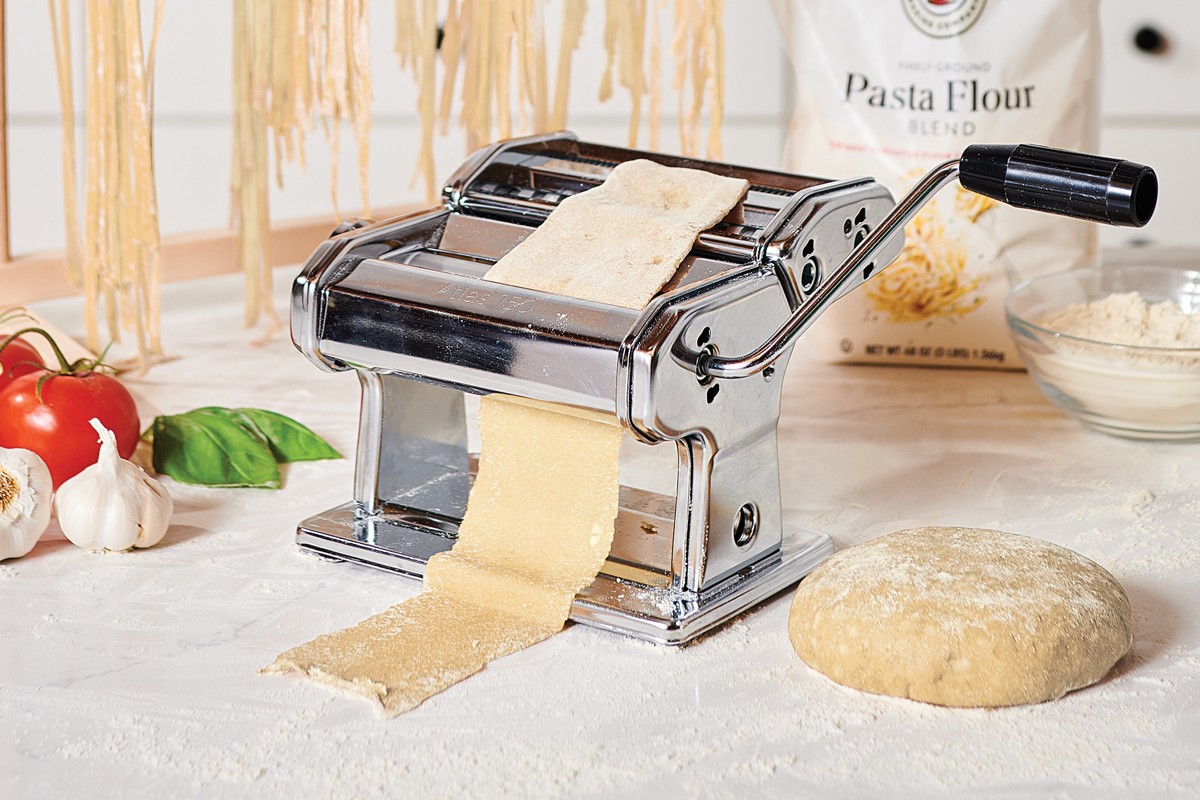 Pasta sheet being run through a pasta machine