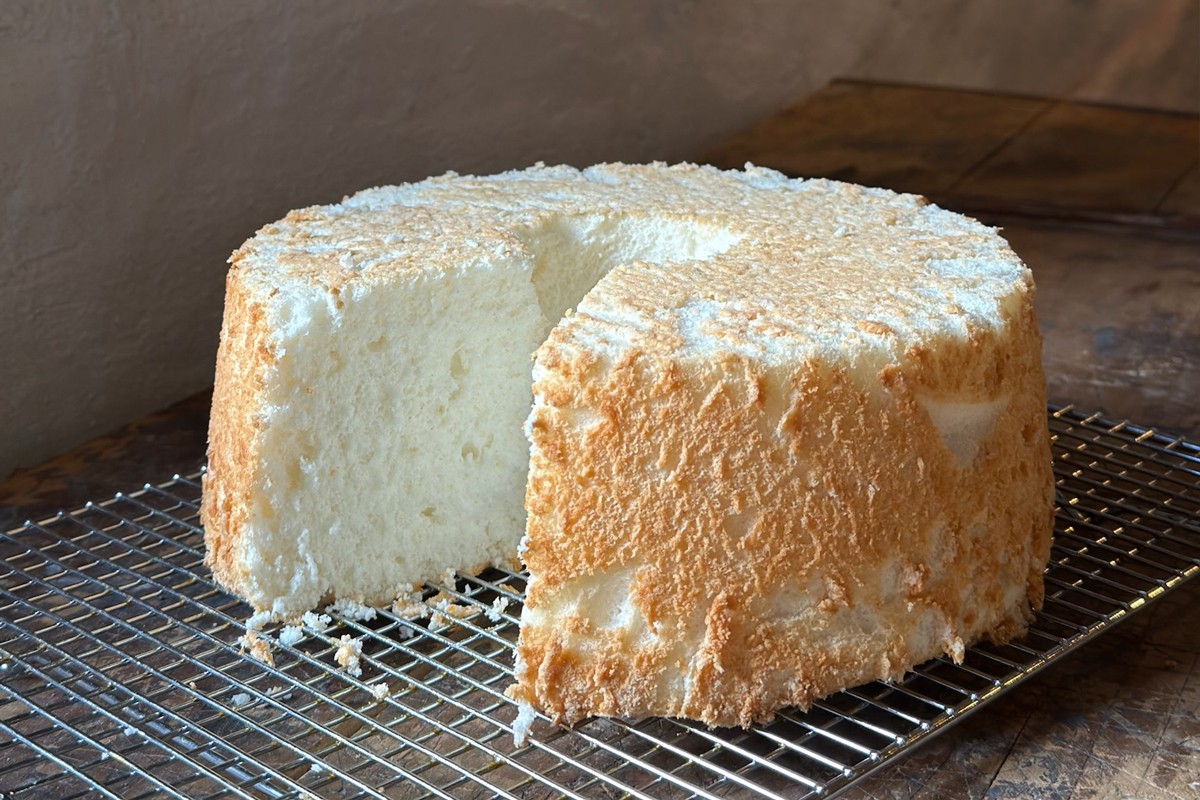 Angel food cake cooled upside-down, with a slice cut out