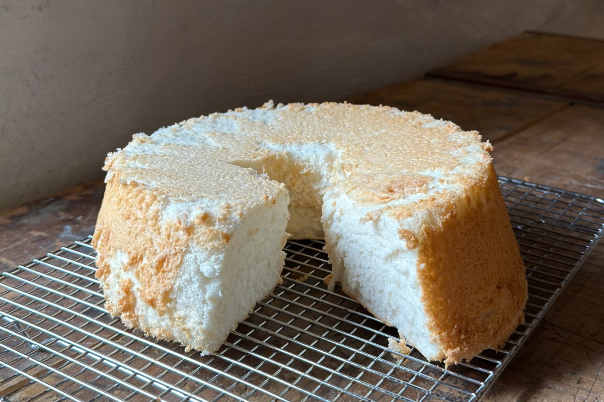 Angel food cake cooled right-side up, with a slice cutout 