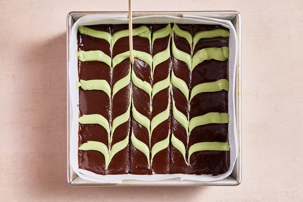 Feathering mint topping into brownie mix.