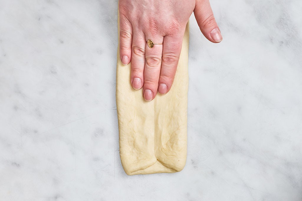 Folding and pressing Sourdough Milk Bread dough into a long rectangle