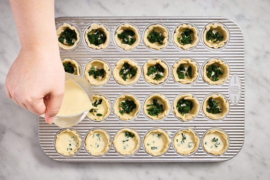 Pouring battering into prepared Mini Quiche cups