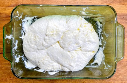 Very slack dough for sourdough Pan de Cristal in a green glass shallow casserole dish