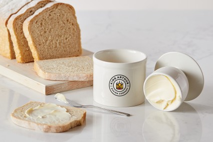 Butter keeper full of butter next to bread