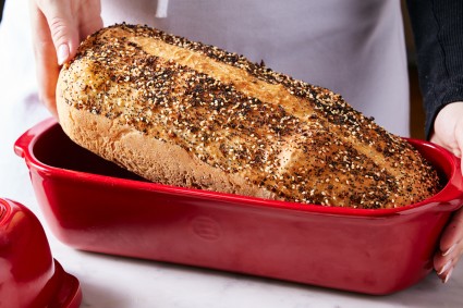 Baker lifting loaf of bread out of pan