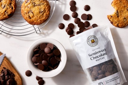 Bag and bowl full of chocolate wafers next to chocolate chip cookies