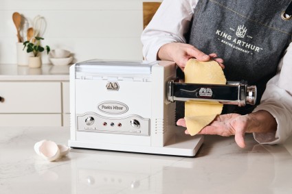 Rolling pasta dough through electric Pasta Fresca machine 
