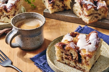 Cinnamon Roll Focaccia on a plate with a cup of coffee