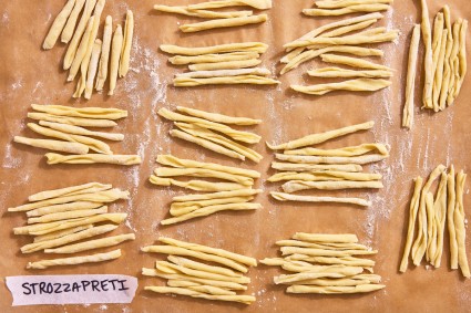 Strozzapreti pasta shape on a parchment-line baking sheet