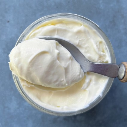 A spoonful of hommade creme fraiche showing its rich, thick texture.
