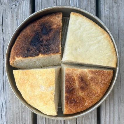 Four wedges of round bread showing the comparative darkness of the bottom crust of each.