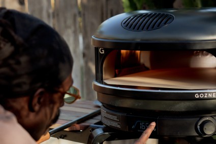 Baker adjusting the temperature on a Gozney pizza oven