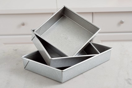 Cake pans of different sizes stacked on top of each other 