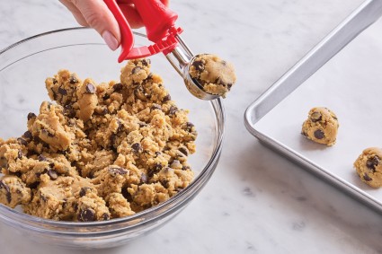 Scooping chocolate chip cookie dough with a scoop