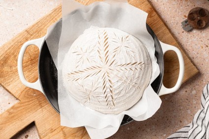 Sourdough bread loaf with a wheat stalk design scored into it 