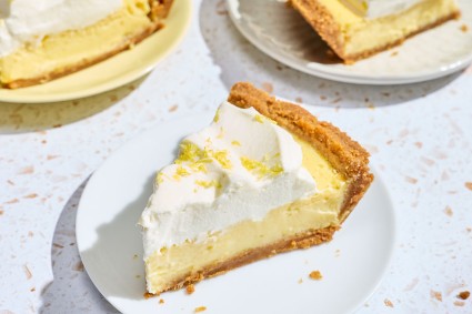 A slice of Lemon Cream Pie on a white plate.
