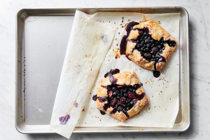 Parchment used to bake galettes halfway pulled back to show clean sheet pan beneath 
