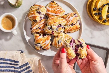 Blueberry Biscuits with Lemon Glaze on a dish with one being broken open