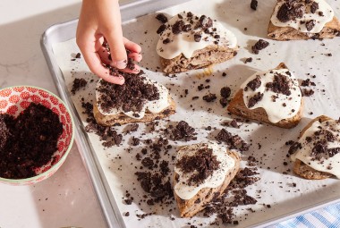 Glazed Cookies-and-Cream Scones being topped with cookie crumbles