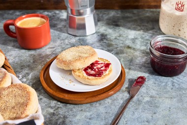 Gluten-Free Sourdough English Muffins made with Bread Flour sliced on a plate with butter and jam