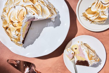 Baked Alaska served on a plate with the full cake on a platter