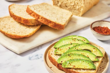 Avocado toast in front of sliced Clay's Multigrain Sourdough bread.