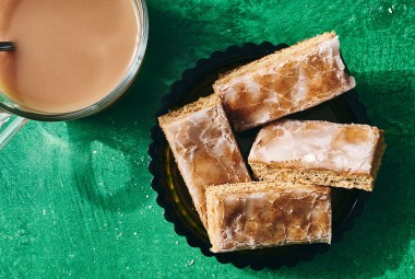 Lebkuchen bars on a plate with a beverage in the corner of the corner of the photo.