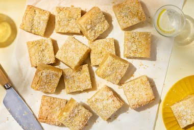Alex Roberts Lemon Citrus Blondies on parchment paper atop a counter.