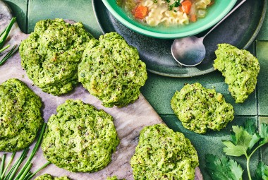 Green Goddess Herb Biscuits on cutting board with a bowl of soup in the frame.