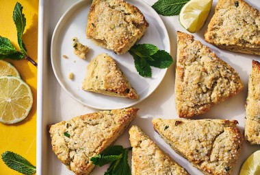 Mojito Scones on a plate and a platter with limes and mint leaves decorating the photo.